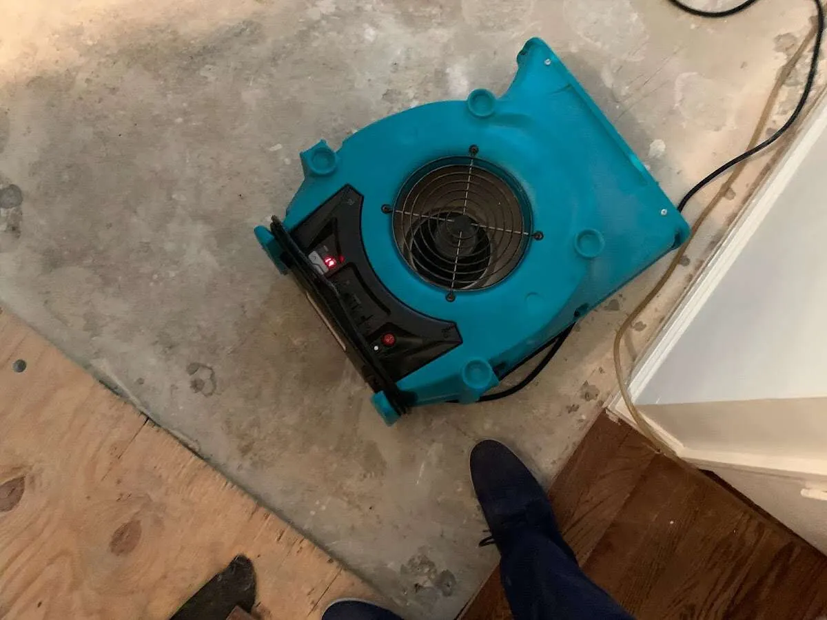 Air mover drying subfloor during Commercial Water Damage Restoration in Aurora
